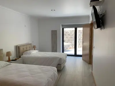 a hotel room with two beds and a flat screen tv at Casa do Ribeiro Frio in Santana