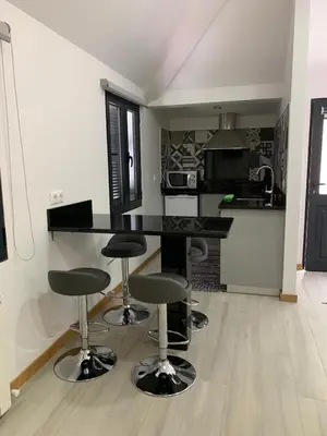 a kitchen with a black counter and bar stools at Casa do Ribeiro Frio in Santana