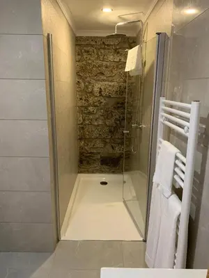 a shower with a glass door in a bathroom at Casa do Ribeiro Frio in Santana