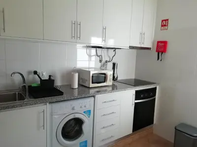 a kitchen with a washing machine and a microwave at Alfazema in Lagos