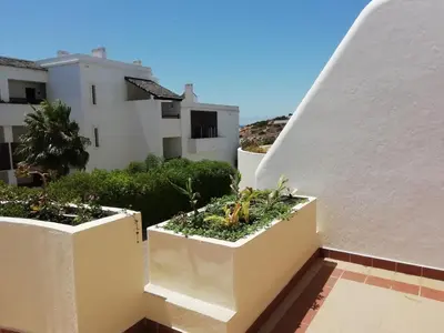 a balcony with two white pots with plants in them at Alfazema in Lagos