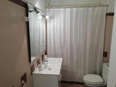 a bathroom with a sink and a toilet and a mirror at Alfazema in Lagos
