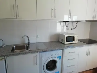 a kitchen with a washing machine and a microwave at Alfazema in Lagos