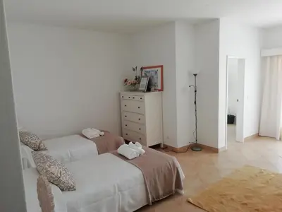 a white bedroom with a bed and a dresser at Alfazema in Lagos