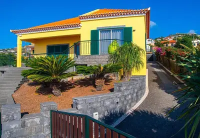 a yellow house with palm trees in front of it at Villa Sunrise View by Homie in Santa Cruz