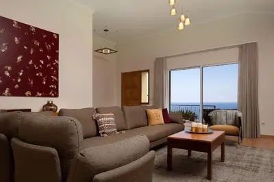 a living room with a couch and a large window at Villa Sunrise View by Homie in Santa Cruz