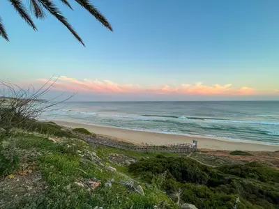 a view of the ocean from a beach with a train at Charming Salema in Salema