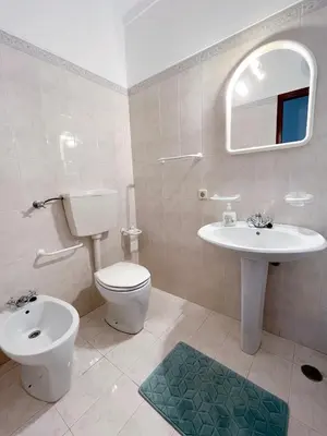 a white bathroom with a toilet and a sink at Charming Salema in Salema
