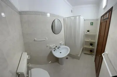 a bathroom with a sink and a toilet and a mirror at Charming Salema in Salema