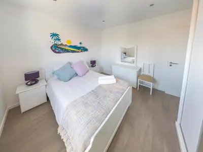 a white bedroom with a bed and a mirror at A Casa do Góis - Villa in Porto Santo in Porto Santo