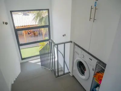 a washing machine in a laundry room with a window at A Casa do Góis - Villa in Porto Santo in Porto Santo