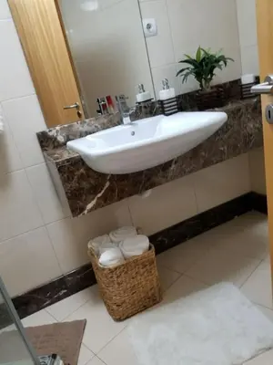 a bathroom with a sink and a basket of towels at VIP Paradise Apartment in Machico