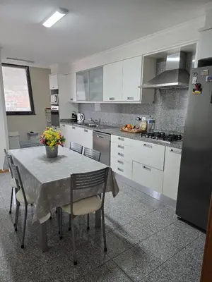 a kitchen with a table with chairs and a refrigerator at VIP Paradise Apartment in Machico