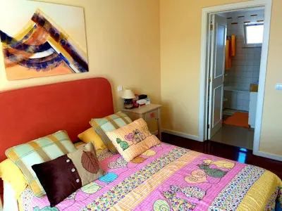 a bedroom with a bed and a painting on the wall at Lido Belissimo in Funchal