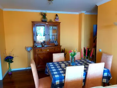 a dining room with a table and chairs and a cabinet at Lido Belissimo in Funchal