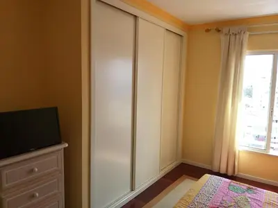a bedroom with a large white cabinet and a window at Lido Belissimo in Funchal