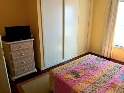 a bedroom with a bed and a dresser with a television at Lido Belissimo in Funchal