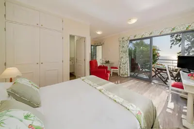a bedroom with a bed and a view of the ocean at Casa do Papagaio Verde in Funchal