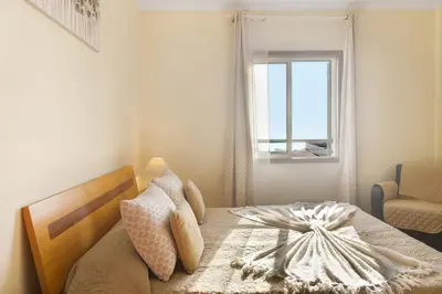 a bedroom with a bed and a window and a chair at Oliveira Atlantic View in Funchal