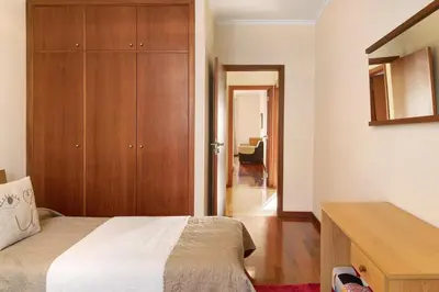 a bedroom with a bed and a wooden cabinet at Oliveira Atlantic View in Funchal