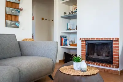 a living room with a couch and a fireplace at Sweet Home Arrifana - Beachhouse by Lisbeyond in Praia da Arrifana