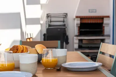 a table with a plate of bread and orange juice at Sweet Home Arrifana - Beachhouse by Lisbeyond in Praia da Arrifana