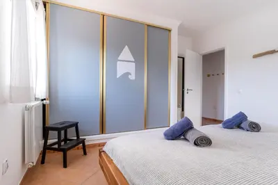 a bedroom with a bed with blue pillows on it at Sweet Home Arrifana - Beachhouse by Lisbeyond in Praia da Arrifana
