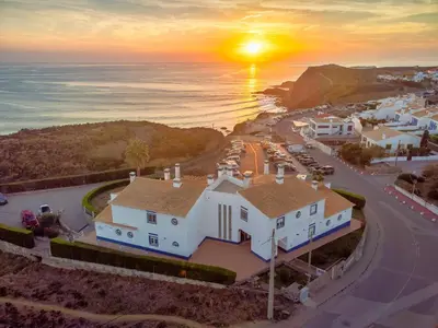 an aerial view of a white house with the sunset at Sweet Home Arrifana - Beachhouse by Lisbeyond in Praia da Arrifana