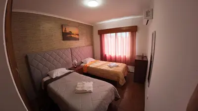 a hotel room with two beds and a window at Apartamentos Lisboa in Vila do Porto