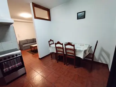 a kitchen with a table and chairs and a couch at Apartamentos Lisboa in Vila do Porto