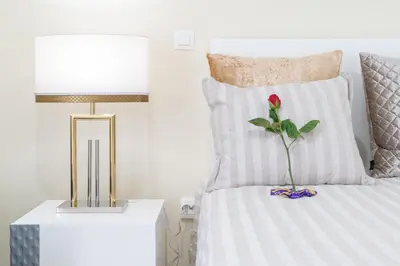 a bedroom with a bed with a lamp and a flower on it at Zeza´s Garden in Calheta