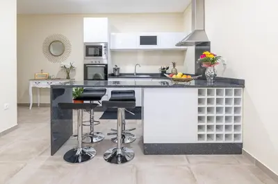 a kitchen with a large island with bar stools at Zeza´s Garden in Calheta