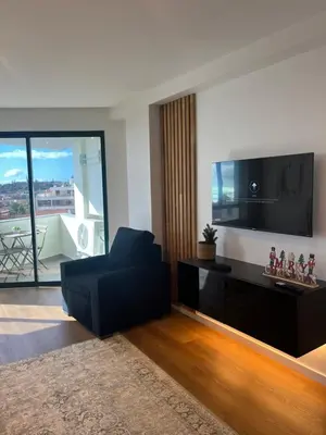 a living room with a black chair and a flat screen tv at Luxury View Apartment Funchal CENTRAL free parking FAMILIES in Funchal