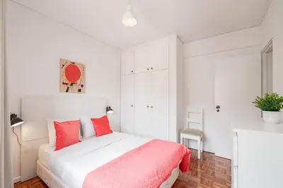a white bedroom with a bed with red pillows at Luxury View Apartment Funchal CENTRAL free parking FAMILIES in Funchal