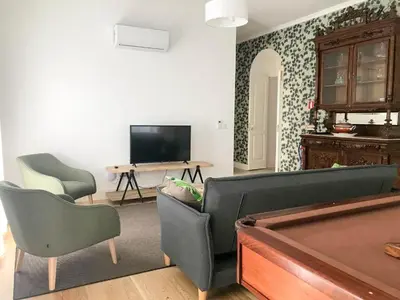 a living room with a tv and a pool table at Casa Oliveira Esmeraldo - Guest Houses in São Vicente