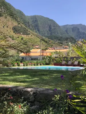 a swimming pool with mountains in the background at Casa Oliveira Esmeraldo - Guest Houses in São Vicente