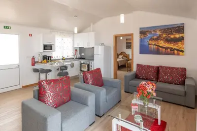 a living room with two couches and a kitchen at Casa Guadalupana in Arco da Calheta
