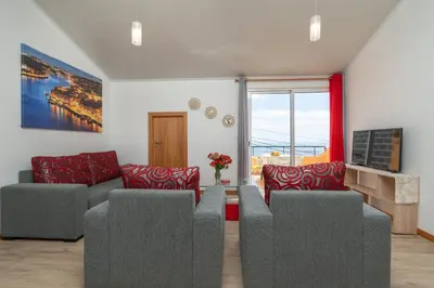 a living room with two couches and a tv at Casa Guadalupana in Arco da Calheta