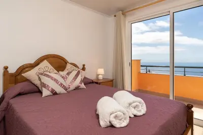 a bedroom with a bed with towels on it at Casa Guadalupana in Arco da Calheta