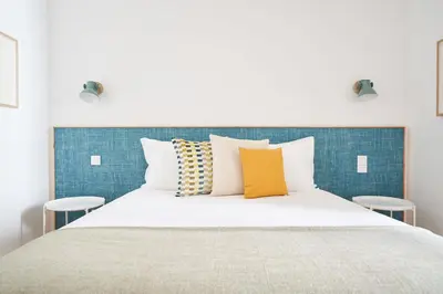 a bedroom with a large white bed with pillows at Good Memories Lodge in Funchal
