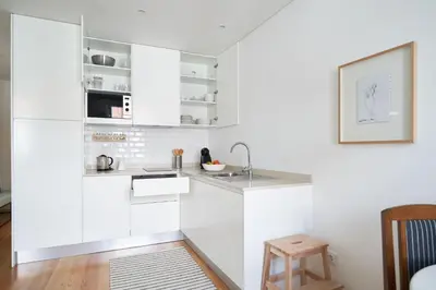 a kitchen with white cabinets and a sink at Good Memories Lodge in Funchal