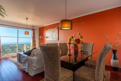 a living room with orange walls and a table and chairs at Barcelos Apartment by Holiday Rental Madeira in Funchal