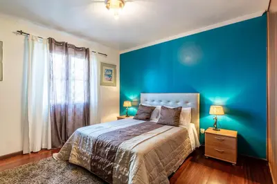 a blue bedroom with a bed and a blue wall at Barcelos Apartment by Holiday Rental Madeira in Funchal