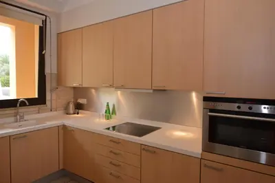 a kitchen with wooden cabinets and a sink at The Navigator - Colombus Apartments & Villas in Porto Santo