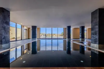 a pool in a building with a view of the water at The Navigator - Colombus Apartments & Villas in Porto Santo