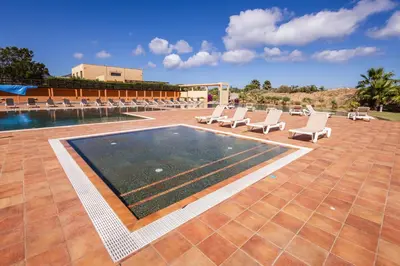 a swimming pool with lounge chairs and a swimming pool at The Navigator - Colombus Apartments & Villas in Porto Santo