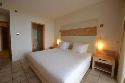 a bedroom with a large white bed and two lamps at The Navigator - Colombus Apartments & Villas in Porto Santo