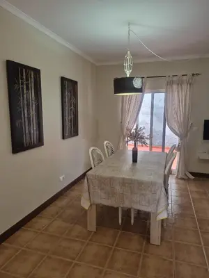 a dining room with a table and chairs and a window at Apartamentos Arrifes 1 in Porto Santo