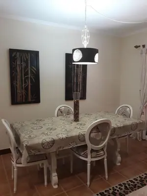 a dining room with a table with chairs and a lamp at Apartamentos Arrifes 1 in Porto Santo
