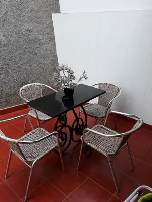 a black table with two chairs and a plant on it at Apartamentos Arrifes 1 in Porto Santo